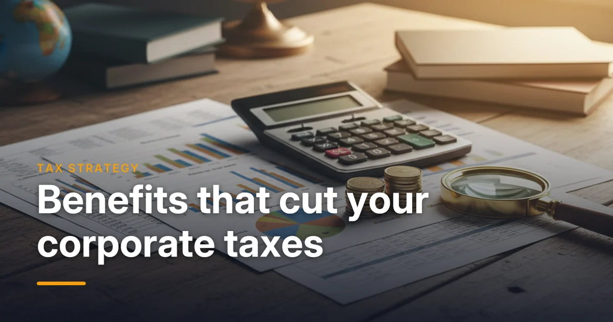 A calculator, tax forms and coins on a desk — using group benefits to reduce corporate taxes in Canada